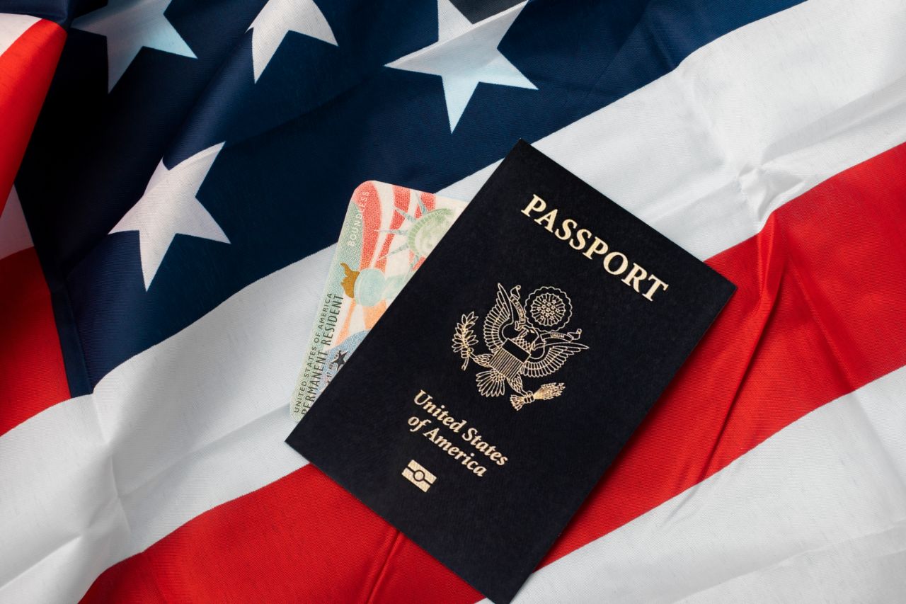 Flag of the United States along with an American Passport - Filing Form N-400: Online or By Mail